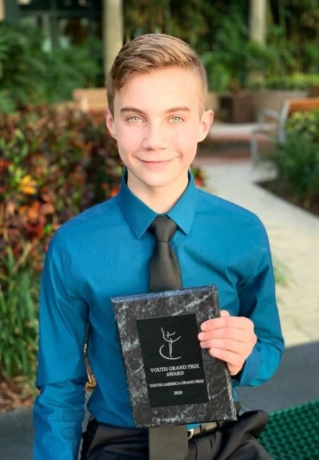 He is posing for a photo with award.